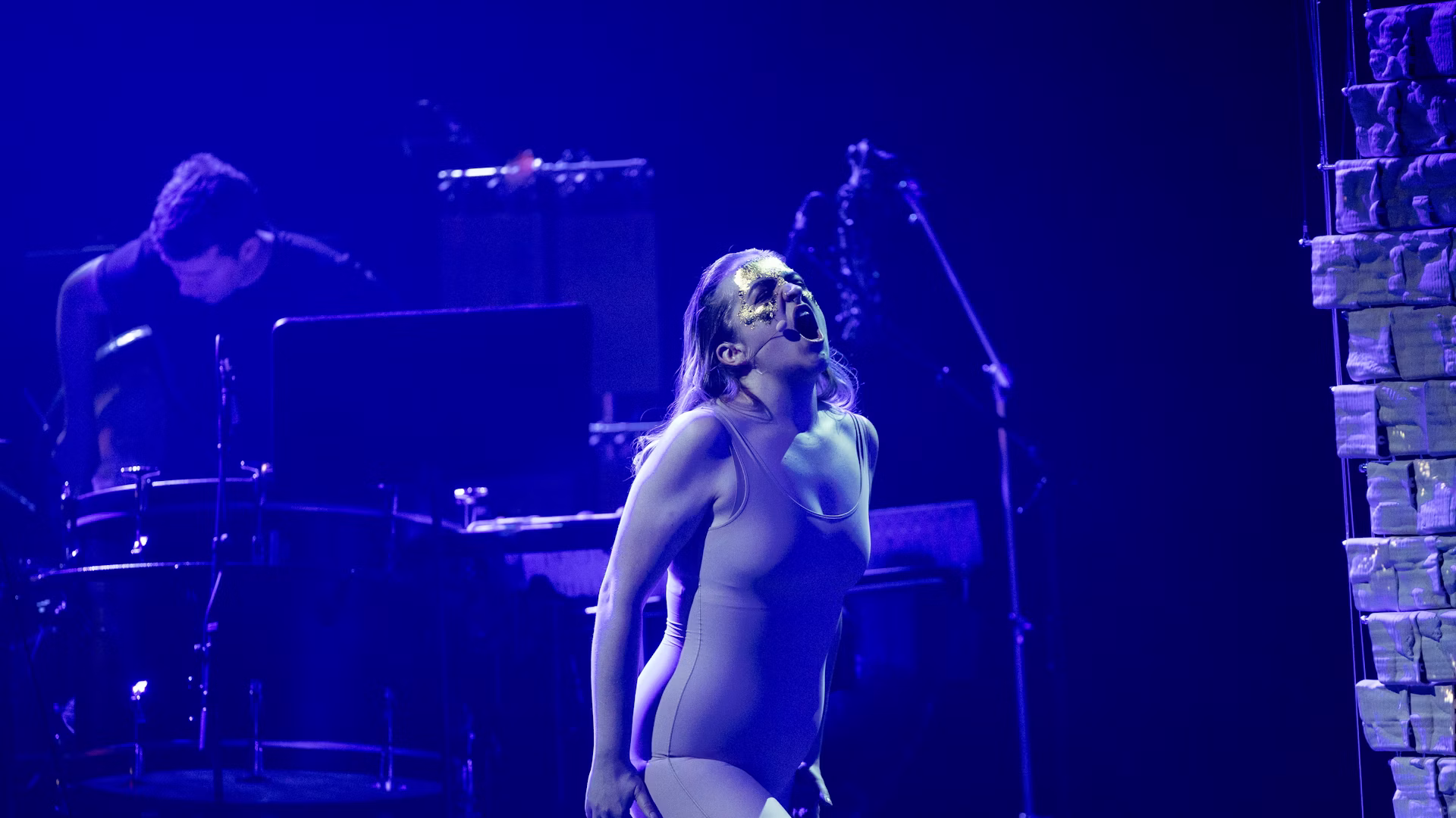 Soprano Laure-Catherine Beyers performs in blue stage light.